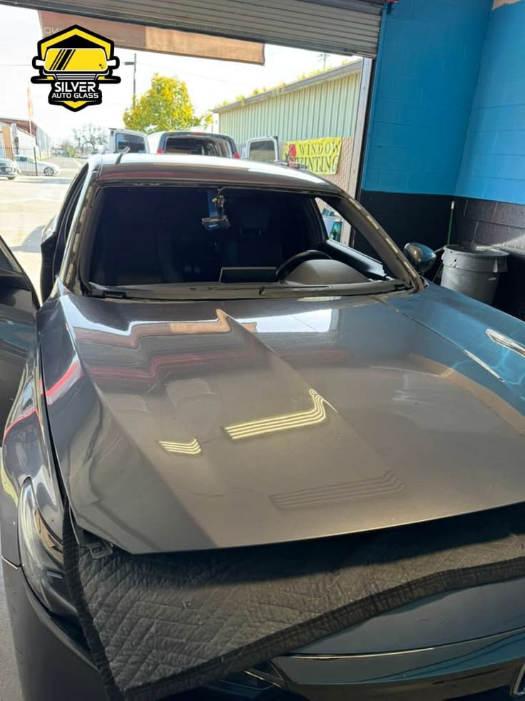 Silver Auto Glass truck with removed windshield displayed in service bay
