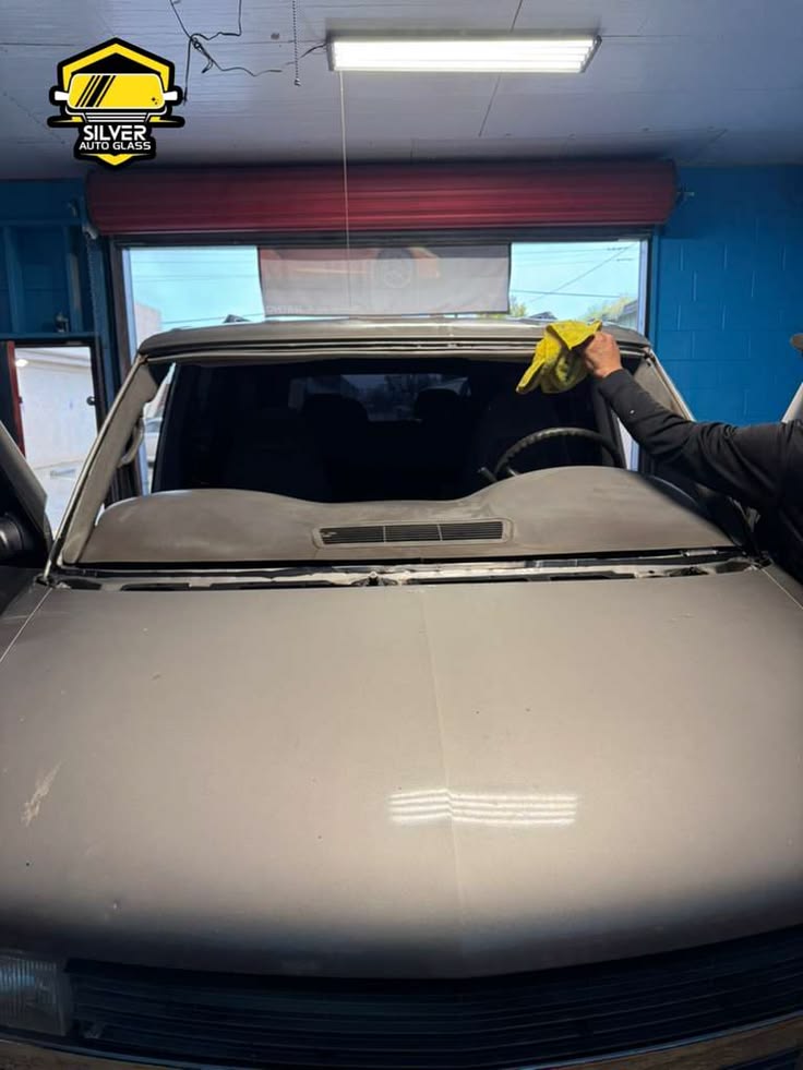 Technician installing windshield on vehicle at Silver Auto Glass shop