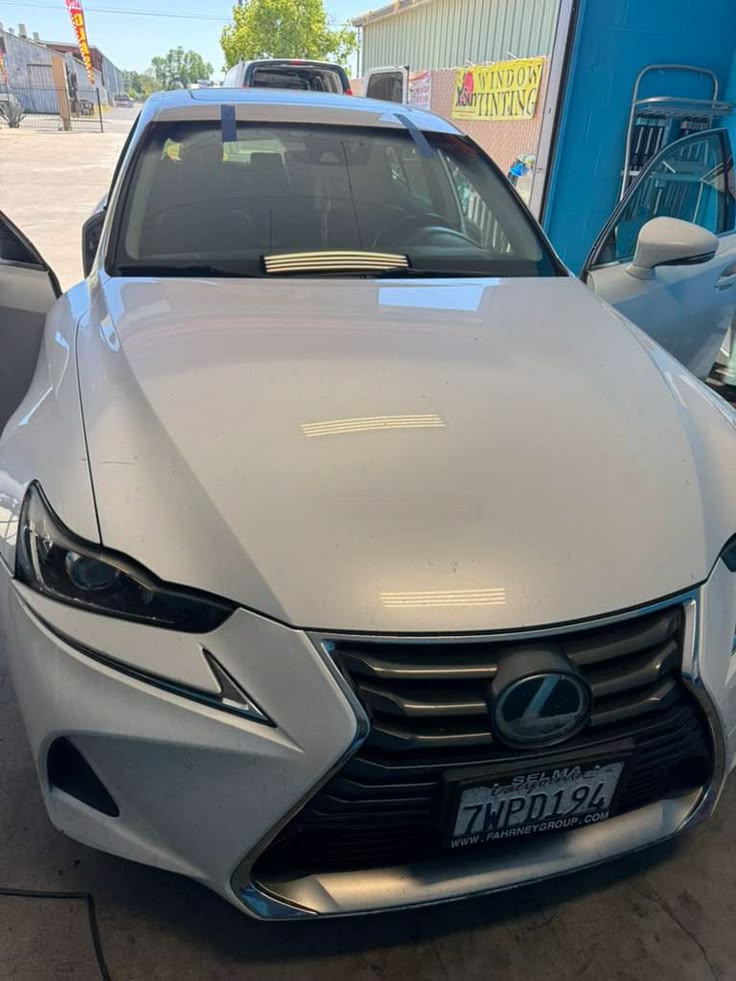 White Lexus SUV parked at dealership lot with tinted windows