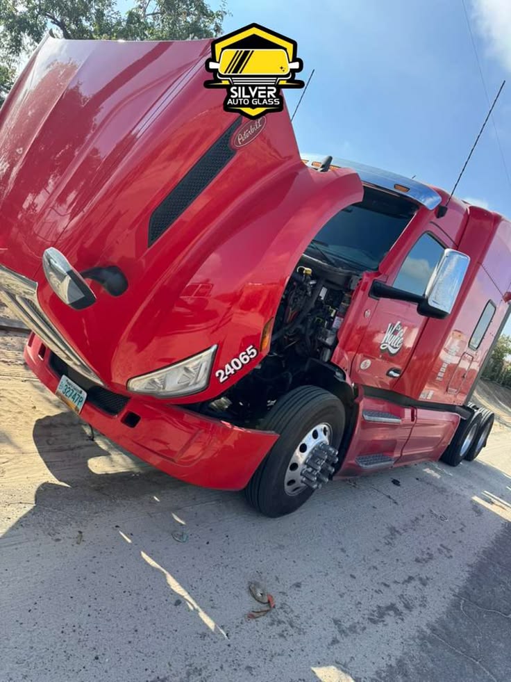 Red semi truck with open hood displaying Silver Auto Glass logo and branding