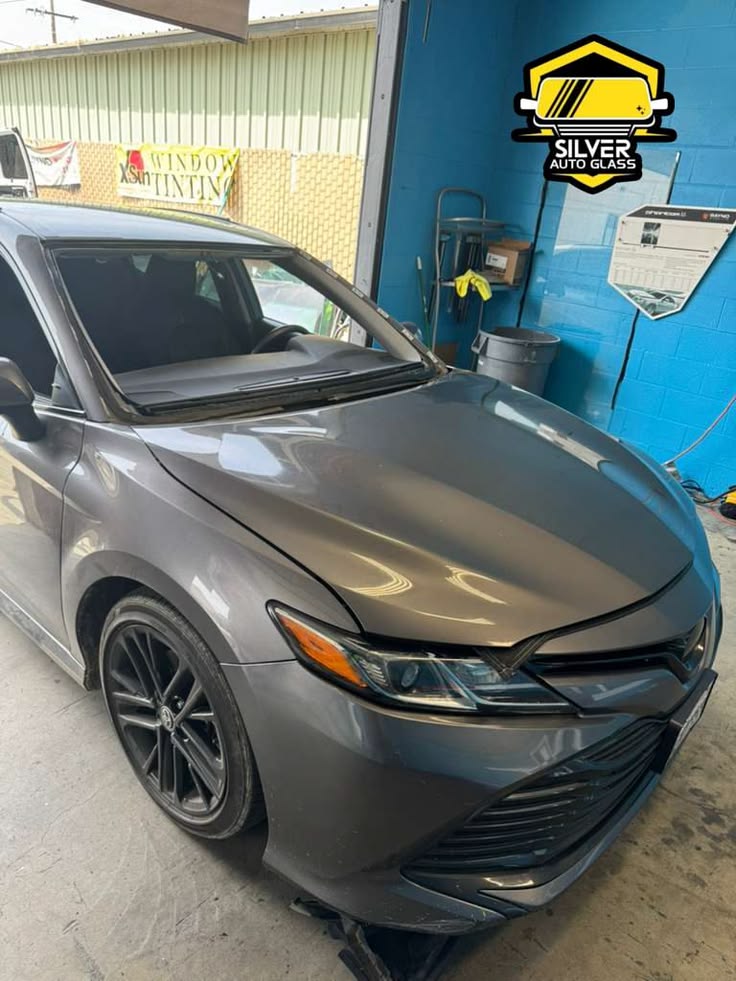 Gray Toyota Camry with windshield removed at Silver Auto Glass shop