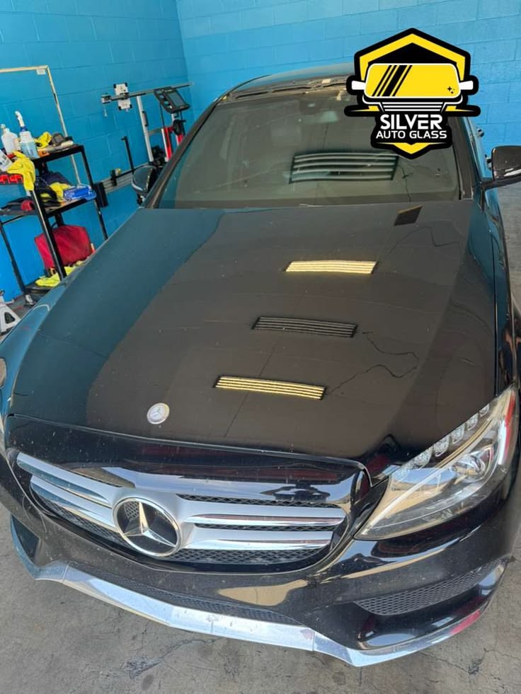 Mercedes-Benz with hood wrap in auto glass shop with Silver Auto Glass logo