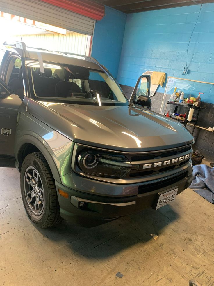 Ford Bronco SUV parked in garage with open doors and blue walls